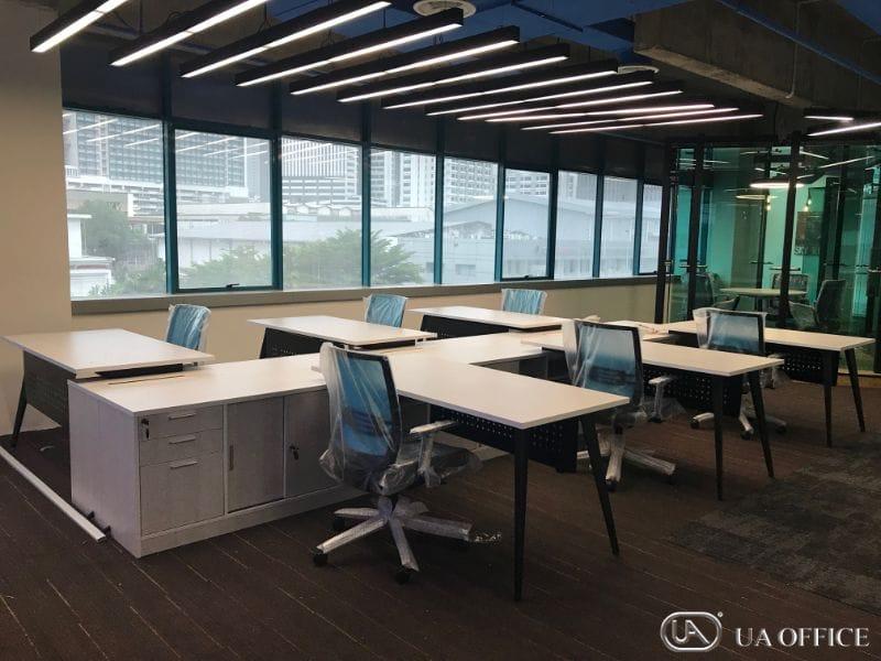 Desks in an open bay along a glazed wall, only low end screens, nothing between facing seats.
