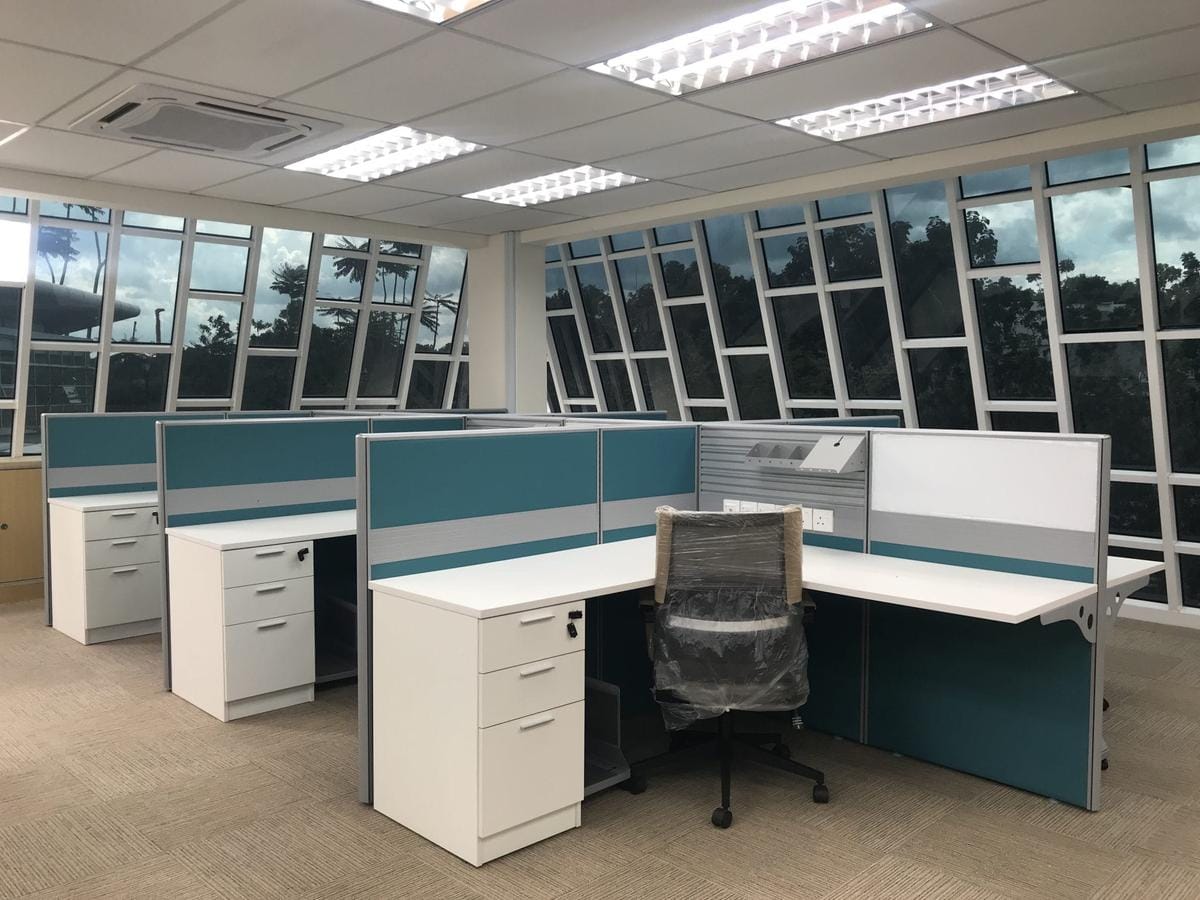 Teal fabric panels screening the desk return and cutting the sightline to the next workstation.