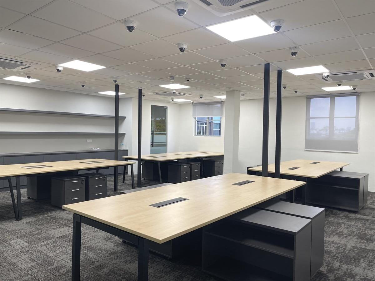 Bench desks running unbroken to the window wall, no screens between positions.
