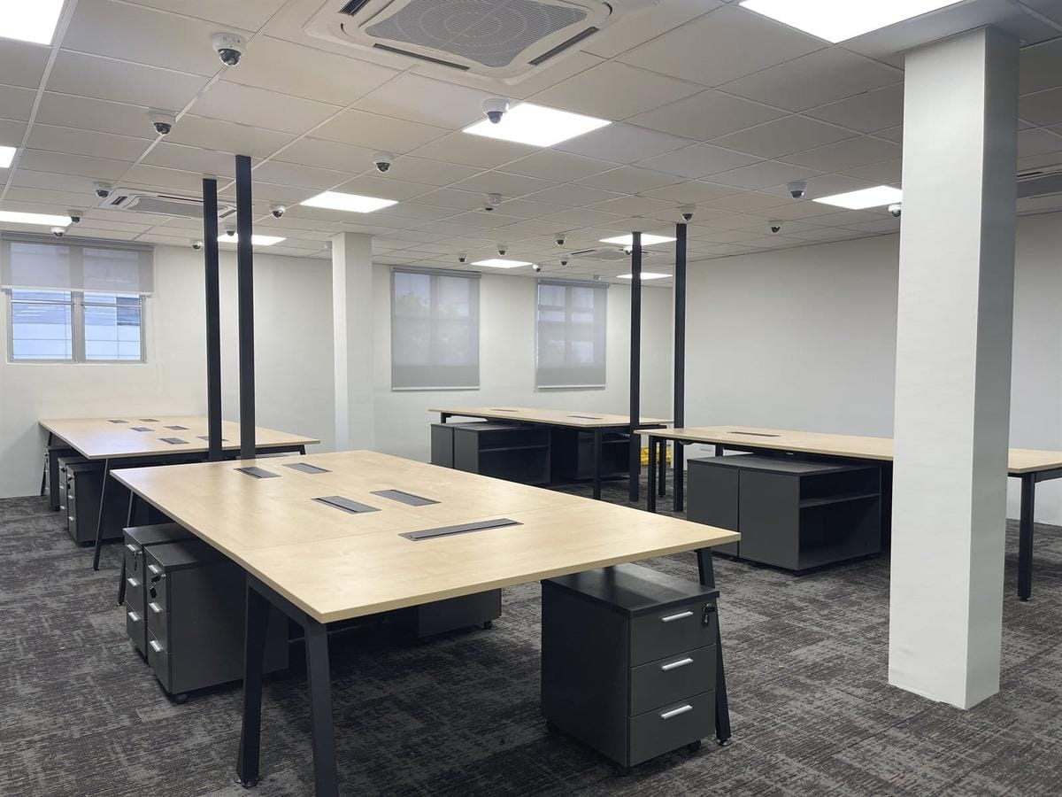Undivided desk rows spanning the full floor plate, sightlines open from end to end.
